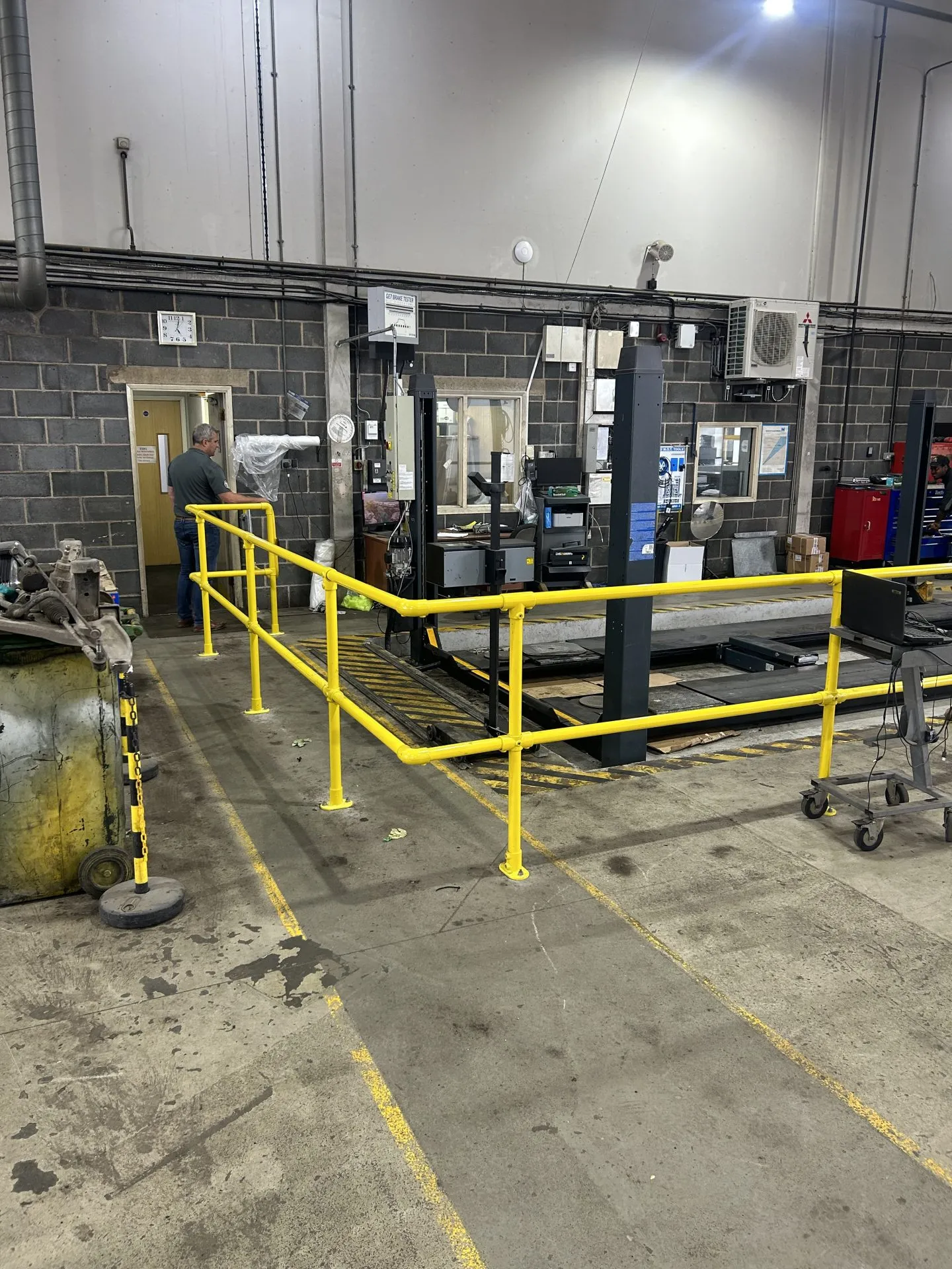 Yellow key clamp safety railing around machinery in a factory